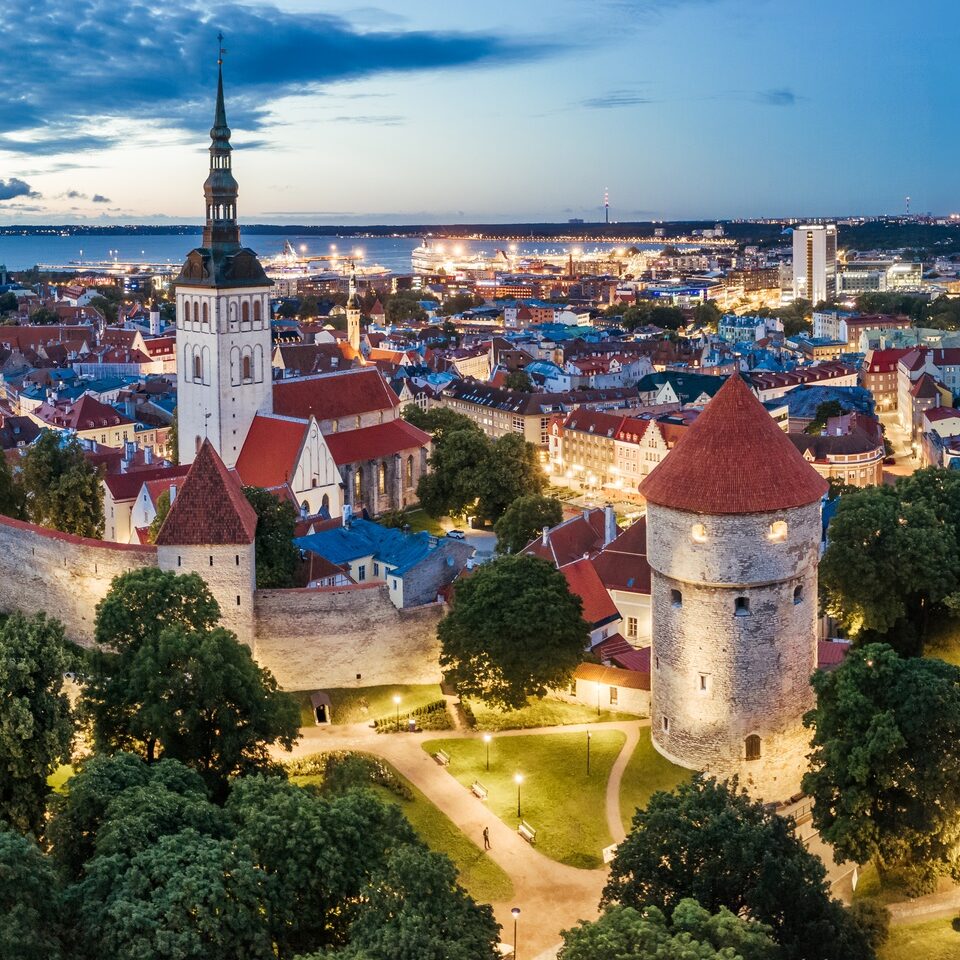 Onde fica a Estônia? A foto mostra alguns edifícios da Cidade Velha de Tallinn, capital da Estônia, iluminados ao anoitecer.